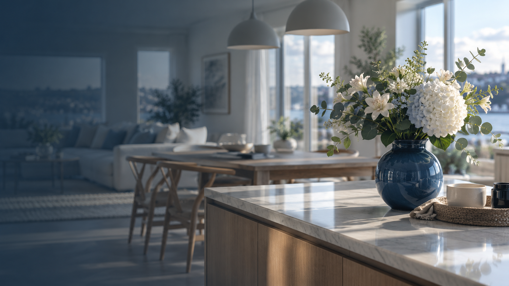 Ljust skandinaviskt hem med blå vas, vita liljor och hydrangea på en köksbänk